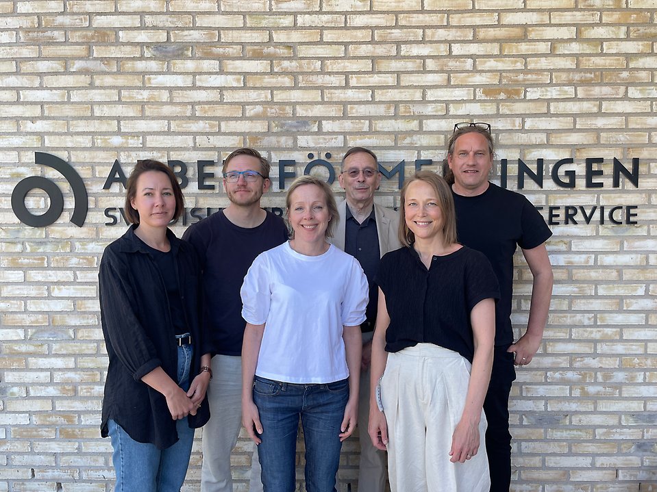 Gruppbild på medlemmarna i Arbetsförmedlingens vetenskapliga råd som står utanför entrén till Arbetsförmedlingens huvudkontor. Lena Hensvik, Johan Vikström, Moa Bursell, Lars Calmfors, Lina Aldén, Tommy Andersson